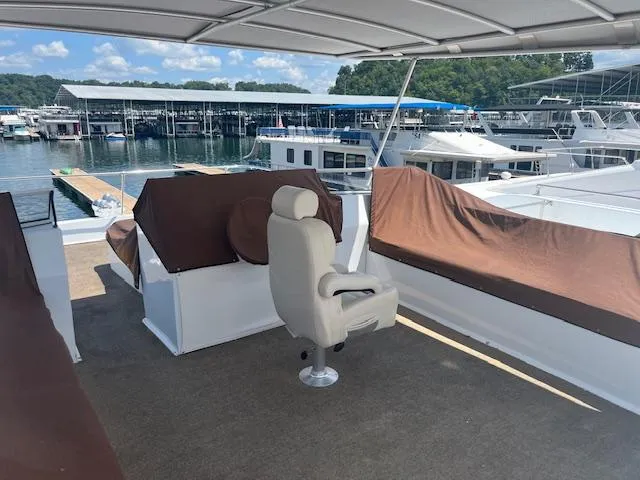 Slide: The Image of 2010 Stardust Cruisers houseboat deck with seating, docked at marina under clear skies. - 48