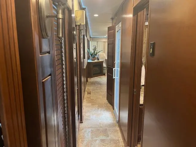 Slide: The Image of Interior hallway of 2010 Stardust Cruisers houseboat with wood paneling and tiled floor. - 9