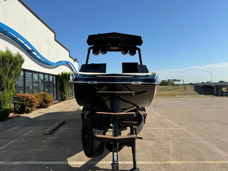 Slide: The Image of 2024 Tigé 24RZX boat on trailer, parked outside dealership under clear blue sky. - 3
