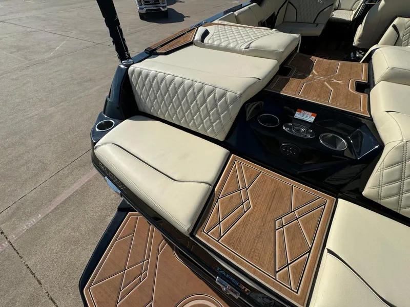 Slide: The Image of 2024 Tigé 24RZX boat interior with beige quilted seats and stylish wood accents. - 7