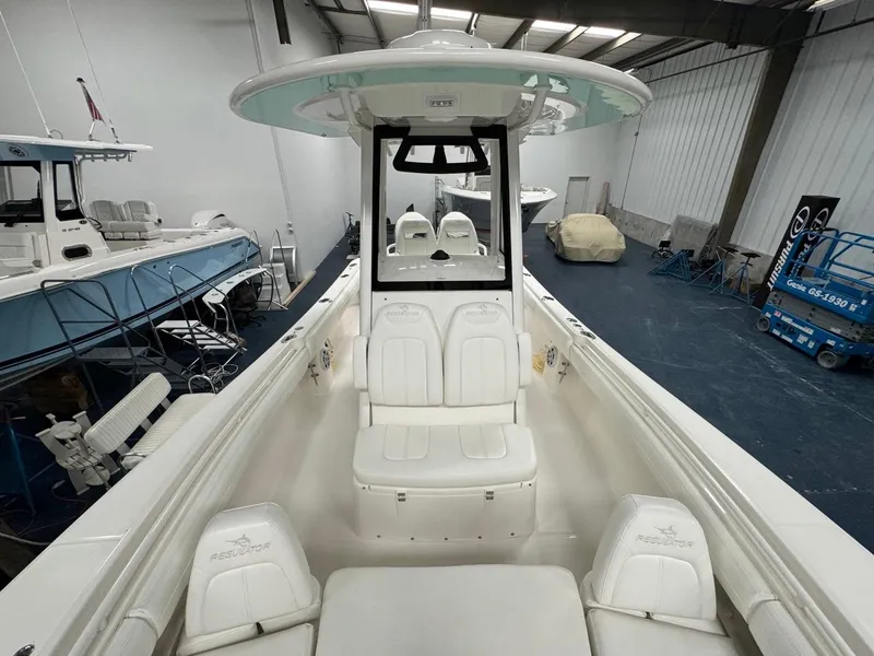 Slide: The Image of 2022 Regulator 25 boat interior with white seating in a showroom. - 10