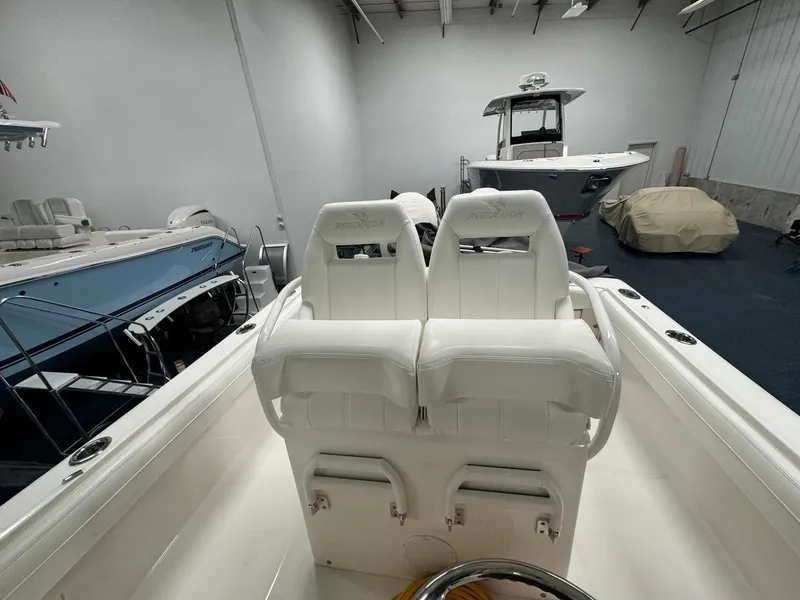 Slide: The Image of 2022 Regulator 25 boat interior with white seating in a showroom. - 11