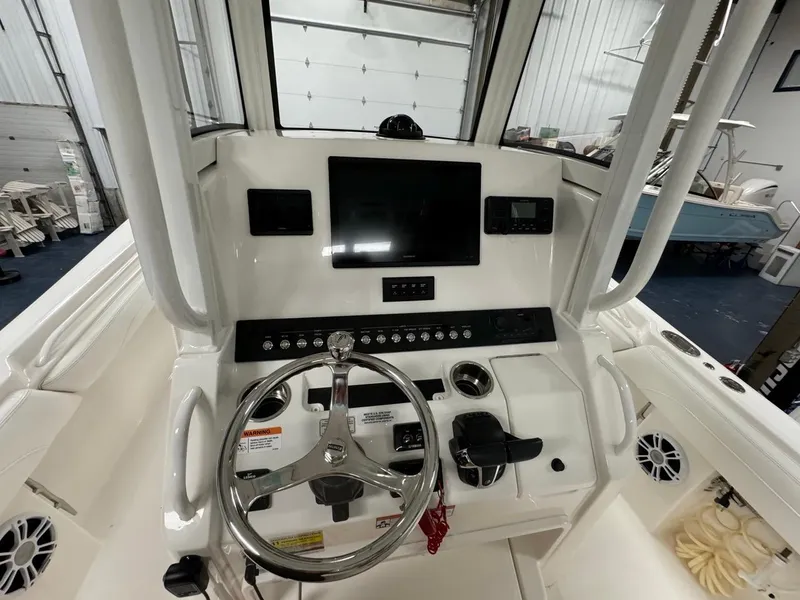 Slide: The Image of 2022 Regulator 25 boat console with steering wheel and electronic controls. - 12