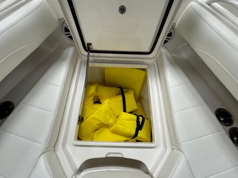 Slide: The Image of Open storage compartment on 2022 Regulator 25 boat with yellow life jackets. - 21