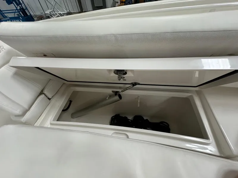 Slide: The Image of 2022 Regulator 25 boat storage compartment with open lid, showcasing interior space. - 22