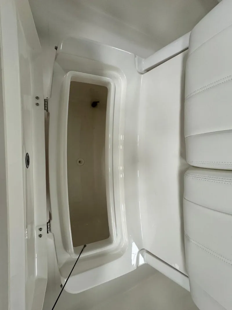 Slide: The Image of 2022 Regulator 25 boat storage compartment with white interior. - 24