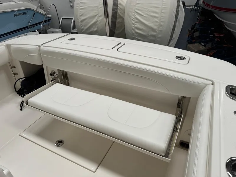 Slide: The Image of 2022 Regulator 25 boat with white cushioned seating and storage compartments. - 30
