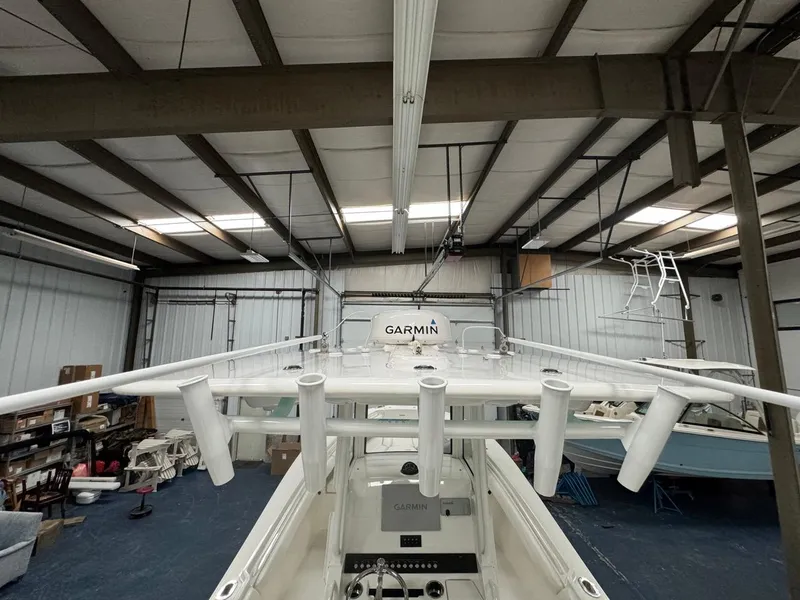 Slide: The Image of 2022 Regulator 25 boat in storage, featuring Garmin equipment and rod holders. - 33