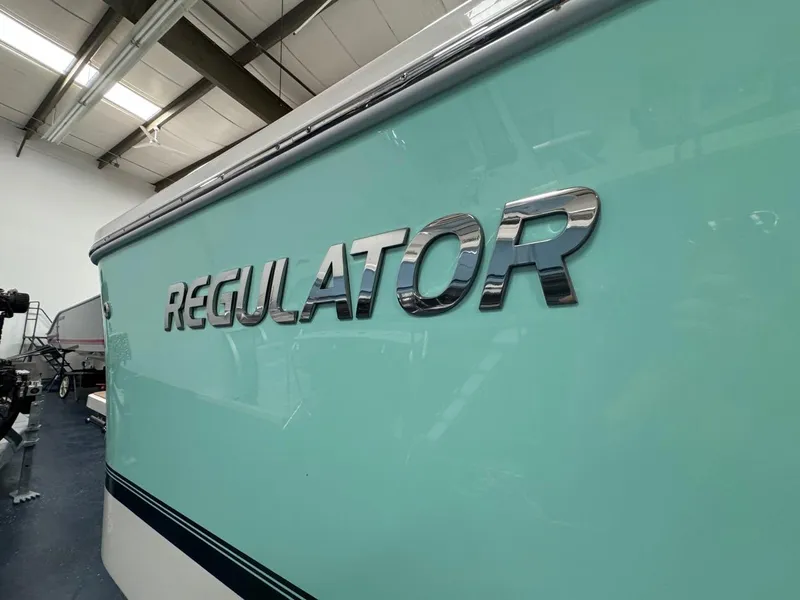 Slide: The Image of 2022 Regulator 25 boat with sleek logo in a showroom. - 45