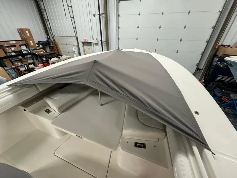 Slide: The Image of 2022 Regulator 25 boat with a gray canopy in a storage facility. - 5