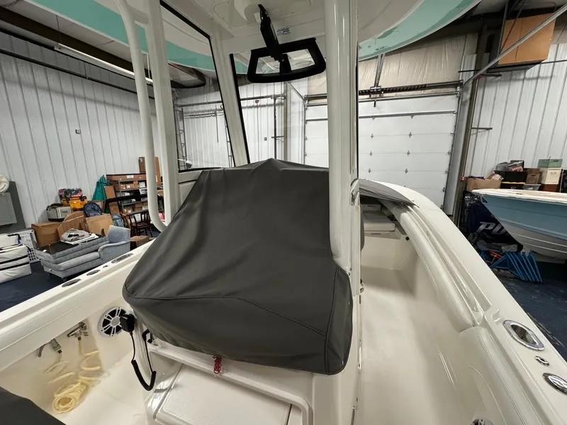 Slide: The Image of 2022 Regulator 25 boat interior in storage, featuring covered console and equipment. - 8