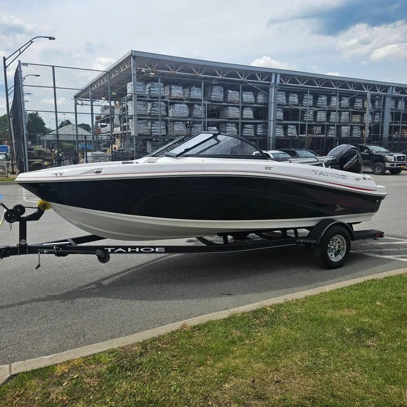 Slide: The Image of 2024 Tahoe 200 S boat on trailer in parking lot, industrial background. - 3