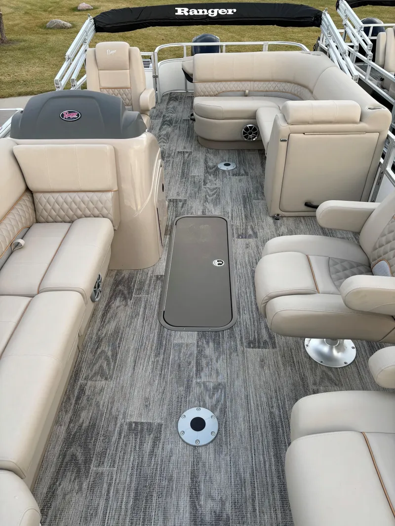 Slide: The Image of 2024 Ranger Reata 223FC pontoon boat interior with beige seating and modern design. - 5