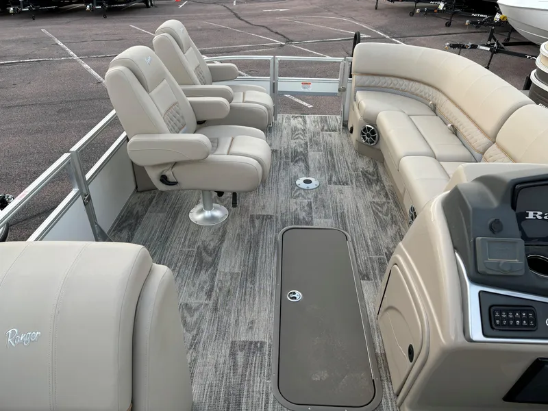 Slide: The Image of 2024 Ranger Reata 223FC boat interior with beige seating and modern console. - 6