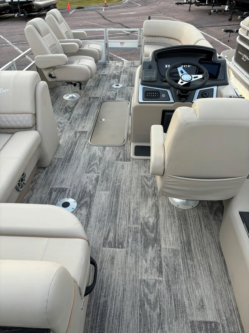 Slide: The Image of 2024 Ranger Reata 223FC boat interior with plush seating and modern dashboard. - 7