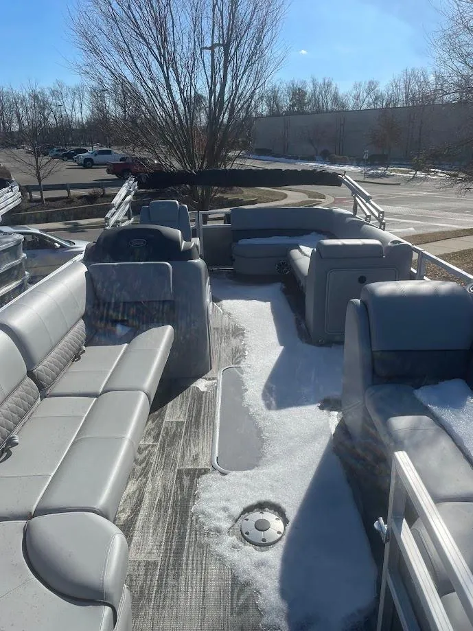 Slide: The Image of 2024 Ranger Reata 223C pontoon boat with snow-covered seats and deck. - 1