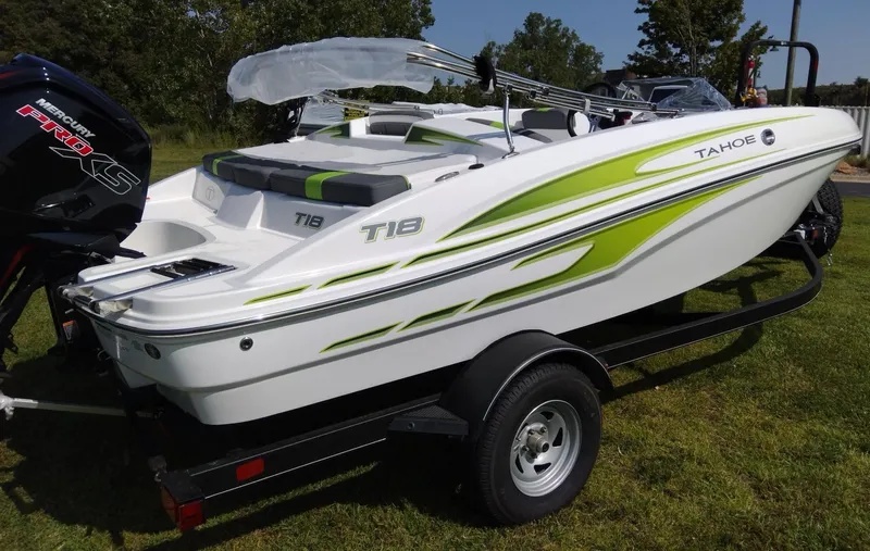 Slide: The Image of 2024 Tahoe T18 boat with green accents on a trailer, parked on grass. - 3