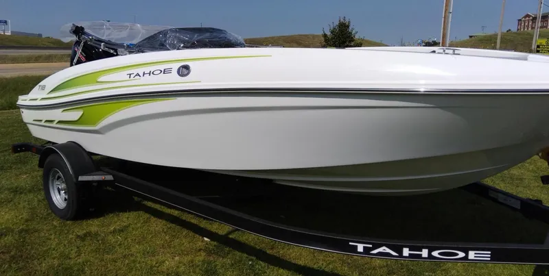 Slide: The Image of 2024 Tahoe T18 boat on trailer, white with green accents, parked on grass. - 4