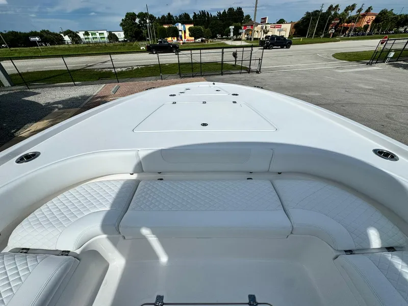 Slide: The Image of 2025 Caymas 281 HB boat interior with white seating and storage compartments. - 13