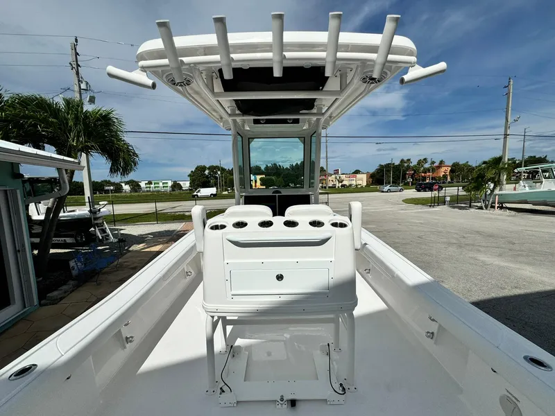 Slide: The Image of 2025 Caymas 281 HB boat with center console and rod holders, parked outdoors. - 5