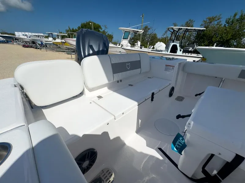 Slide: The Image of 2025 Sea Fox 228 Commander boat interior with seating and storage, docked outdoors. - 11