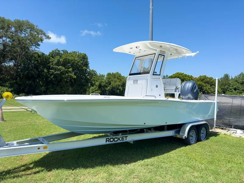 Slide: The Image of 2025 Sea Fox 231 Bay Fox boat on trailer, parked on grass under clear blue sky. - 12