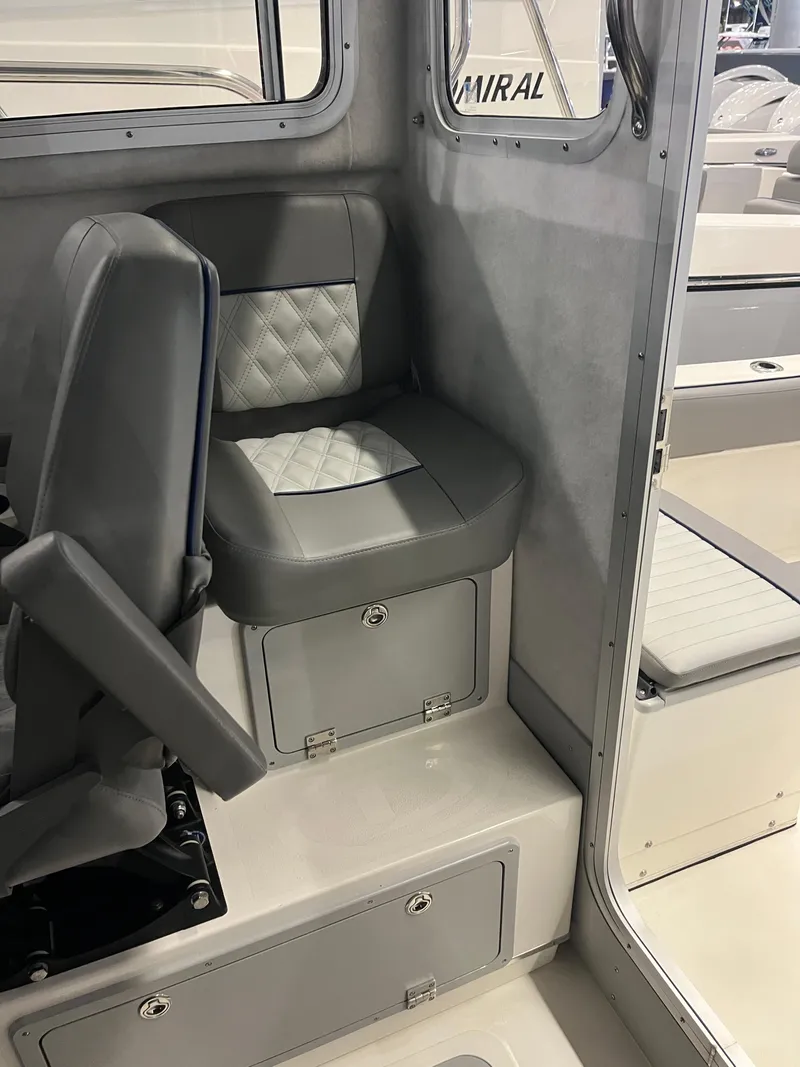 Slide: The Image of Interior of 2025 Defiance Admiral 220 EX boat with cushioned seating and storage compartments. - 9