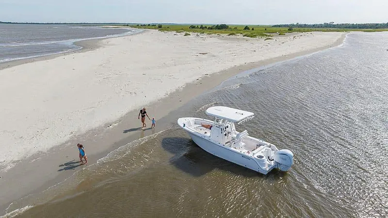 Slide: The Image of 2025 Sea Fox 248 Side Console boat on sandy beach with people nearby. - 9