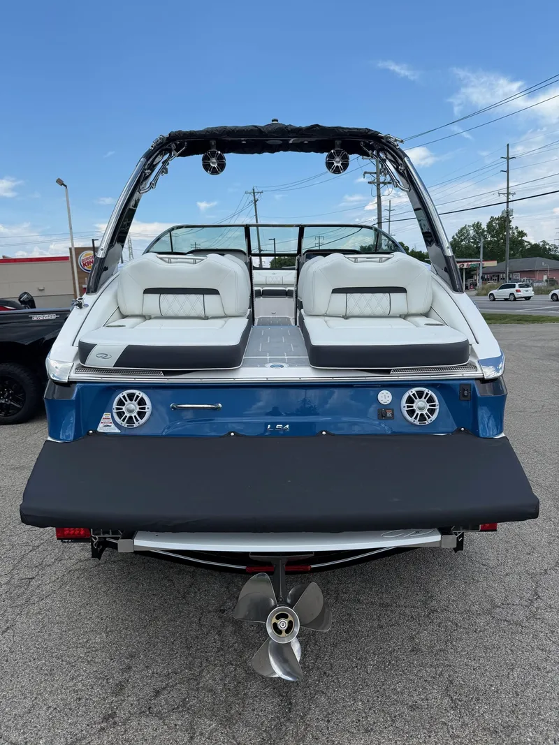 Slide: The Image of 2025 Regal LS4 boat, rear view with seating and propeller, parked outdoors. - 11