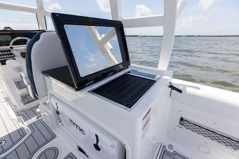 Slide: The Image of Sea Fox 268 Traveler 2025 boat interior with grill and seating, on open water. - 15