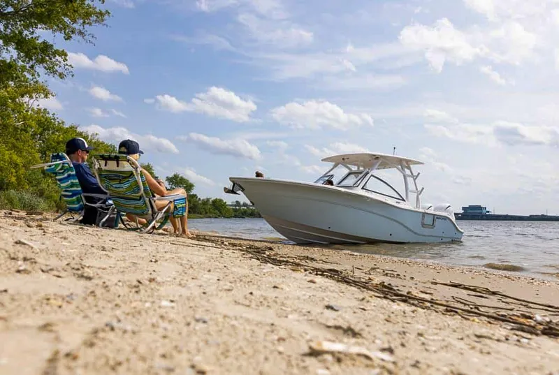 Slide: The Image of 2025 Sea Fox 268 Traveler boat near sandy beach with two people relaxing in chairs. - 36