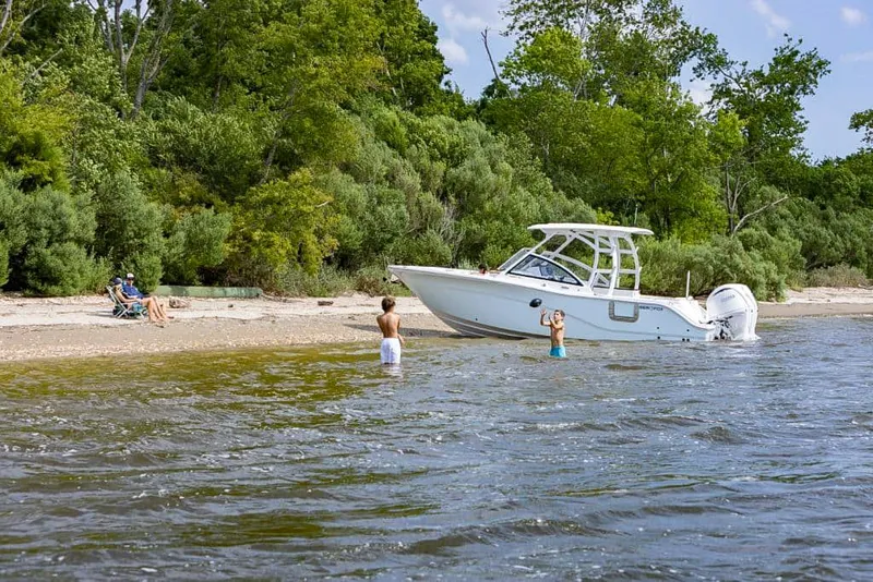 Slide: The Image of 2025 Sea Fox 268 Traveler boat on a scenic beach with children playing nearby. - 7