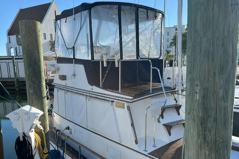 Slide: The Image of 1978 Grand Banks 38 boat docked at a marina with covered upper deck. - 1