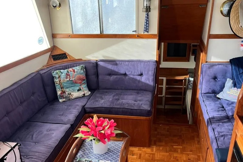 Slide: The Image of Interior of 1978 Grand Banks 38 with purple seating and decorative pillow. - 12