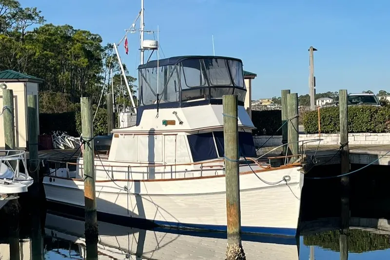 Slide: The Image of 1978 Grand Banks 38 boat docked at marina, clear sky background. - 2