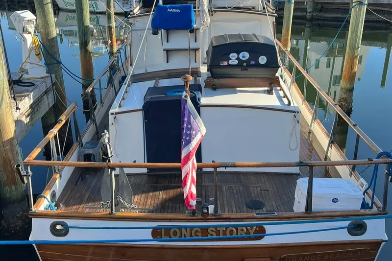Slide: The Image of 1978 Grand Banks 38 boat docked, displaying American flag, named "Long Story." - 6