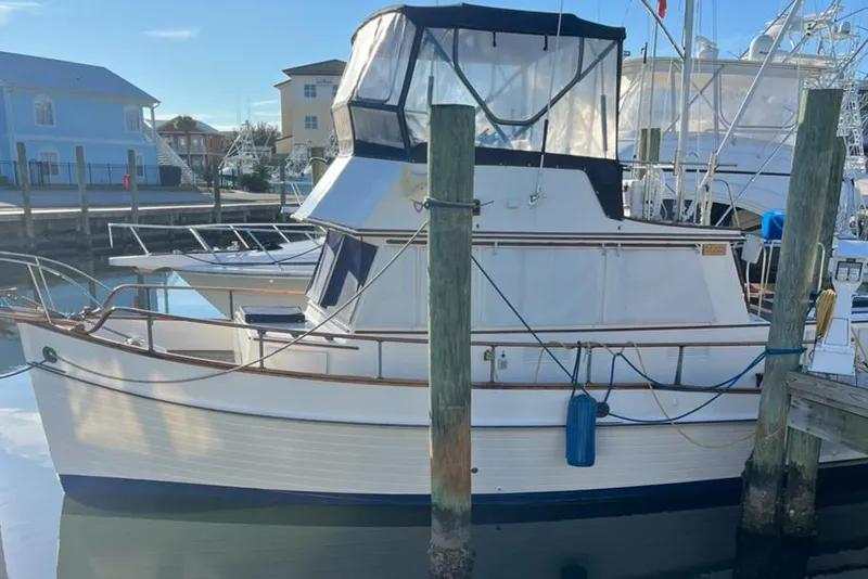 Slide: The Image of 1978 Grand Banks 38 boat docked in a marina, featuring classic design and wooden details. - 7