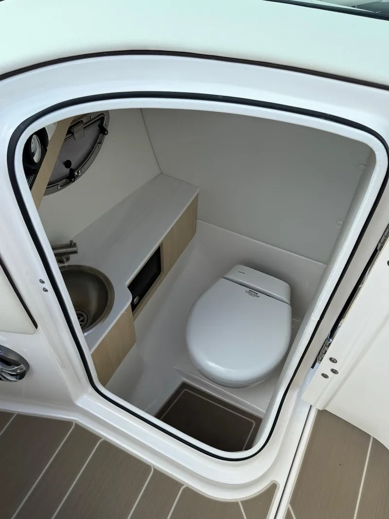 Slide: The Image of 2025 Regal LS6 boat interior bathroom with modern toilet and sink. - 7