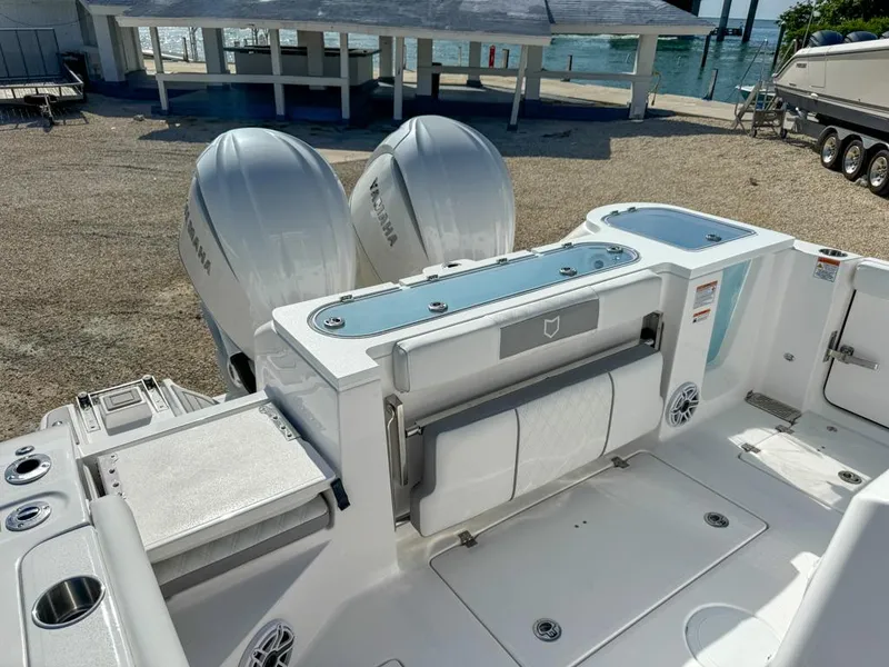 Slide: The Image of 2025 Sea Fox 328 Commander boat with dual outboard engines, docked near a waterfront. - 7