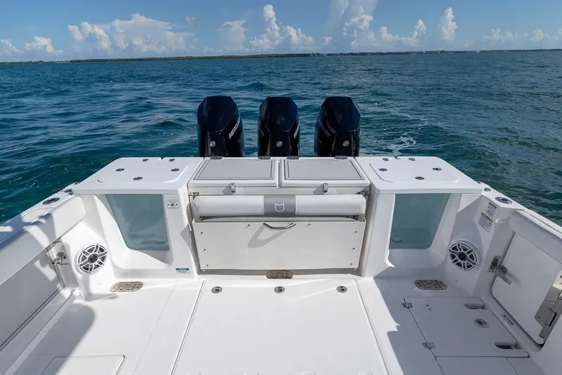 Slide: The Image of 2025 Sea Fox 368 Commander boat deck with triple outboard engines on open water. - 18