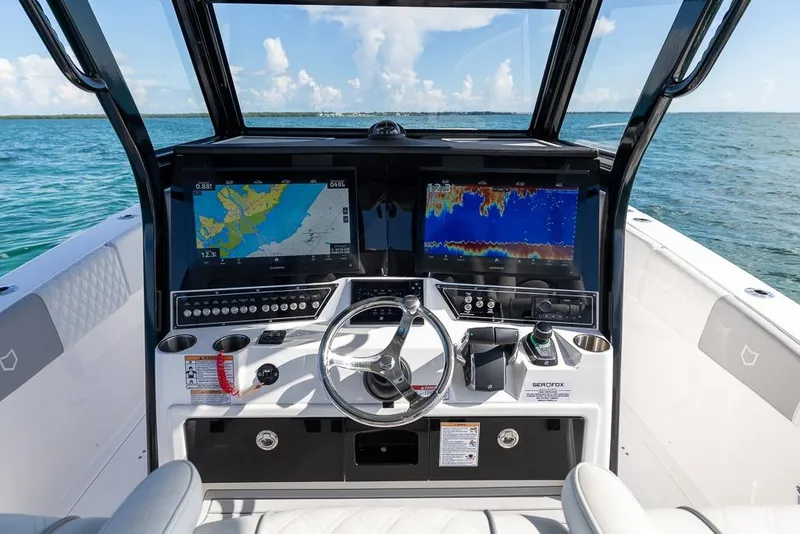 Slide: The Image of 2025 Sea Fox 368 Commander helm with dual navigation screens on open water. - 23