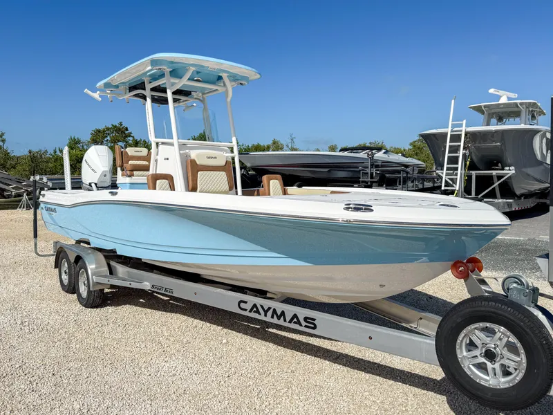 Slide: The Image of 2024 Caymas 26 HB boat on trailer, light blue hull, parked outdoors. - 1