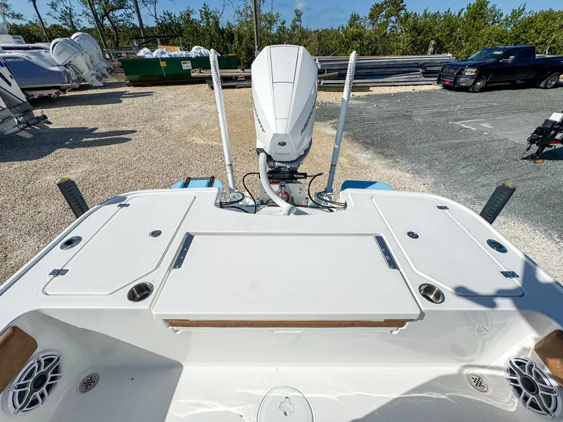 Slide: The Image of 2024 Caymas 26 HB boat with outboard motor in a parking area. - 10