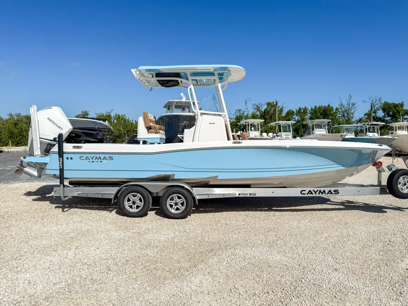 Slide: The Image of 2024 Caymas 26 HB boat on trailer, light blue hull, parked outdoors. - 2