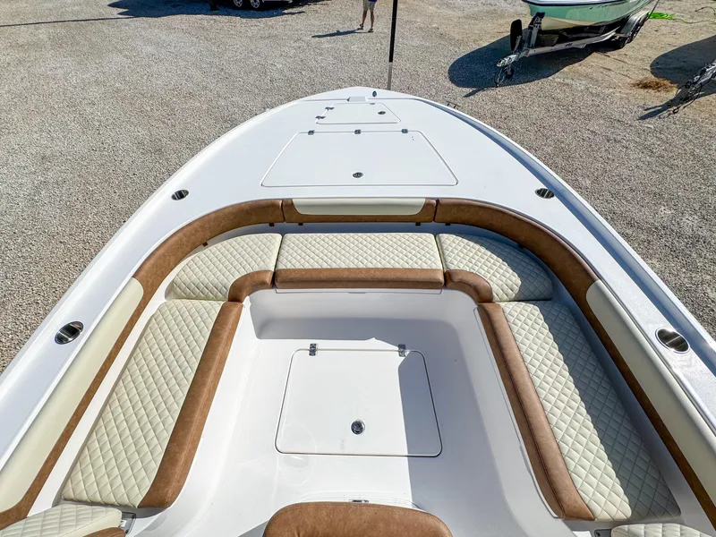 Slide: The Image of 2024 Caymas 26 HB boat with cushioned seating and storage compartments. - 20