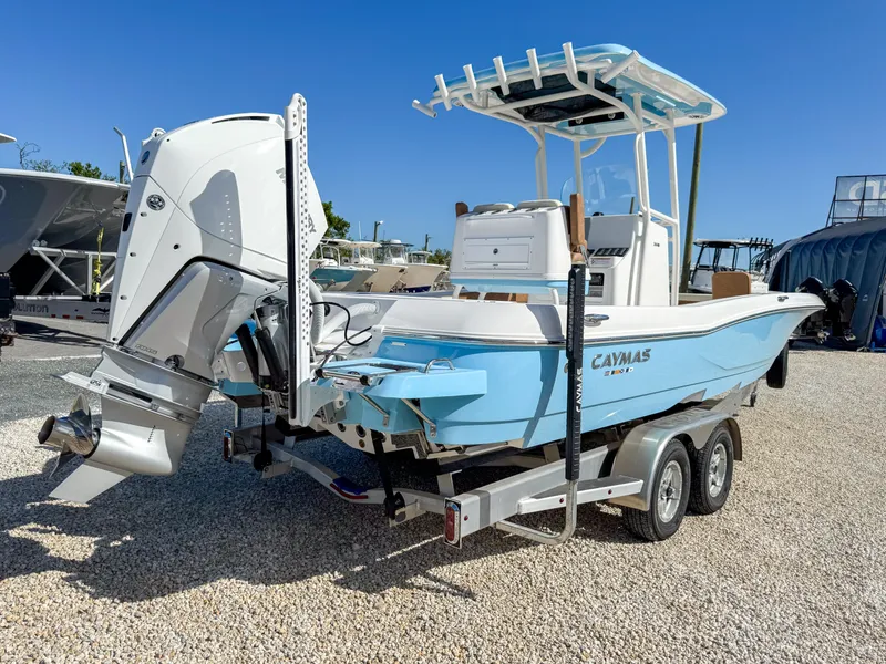 Slide: The Image of 2024 Caymas 26 HB boat on trailer, light blue hull, powerful outboard motor. - 3