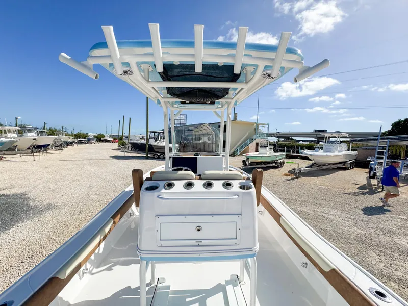 Slide: The Image of 2024 Caymas 26 HB boat with T-top, docked under clear blue sky. - 8