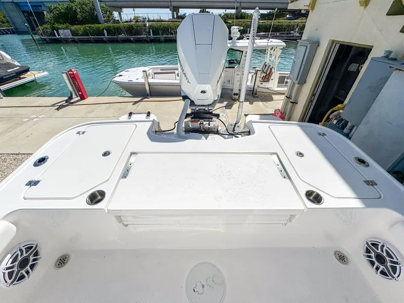Slide: The Image of 2024 Caymas 26 HB boat at dock, featuring spacious deck and powerful outboard motor. - 10
