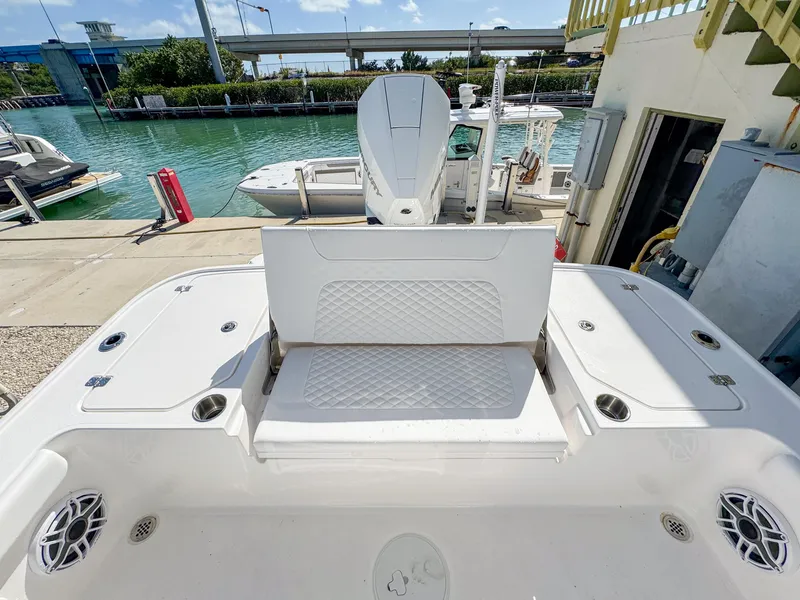 Slide: The Image of 2024 Caymas 26 HB boat with spacious seating, docked near a waterfront. - 11