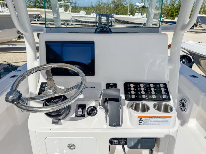 Slide: The Image of 2024 Caymas 26 HB boat dashboard with steering wheel, controls, and display screen. - 12